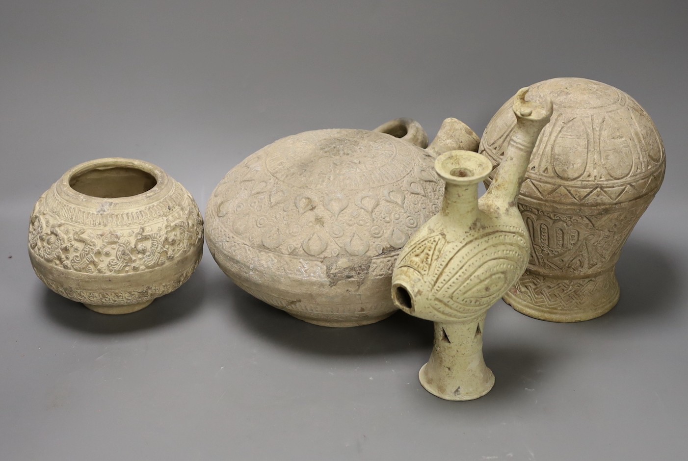 A selection of four Islamic terracotta vessels, Middle Eastern possibly 12th century, the animal headed ewer 22 cm high